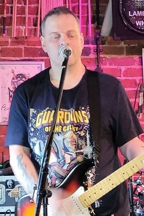 Alan Smith playing guitar and singing