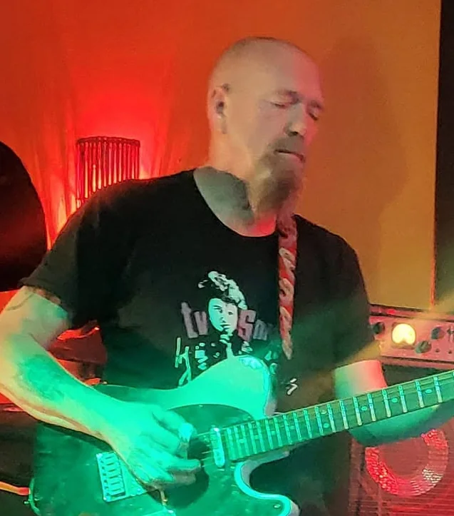 Chris Mayor playing guitar with Electric Outlawz